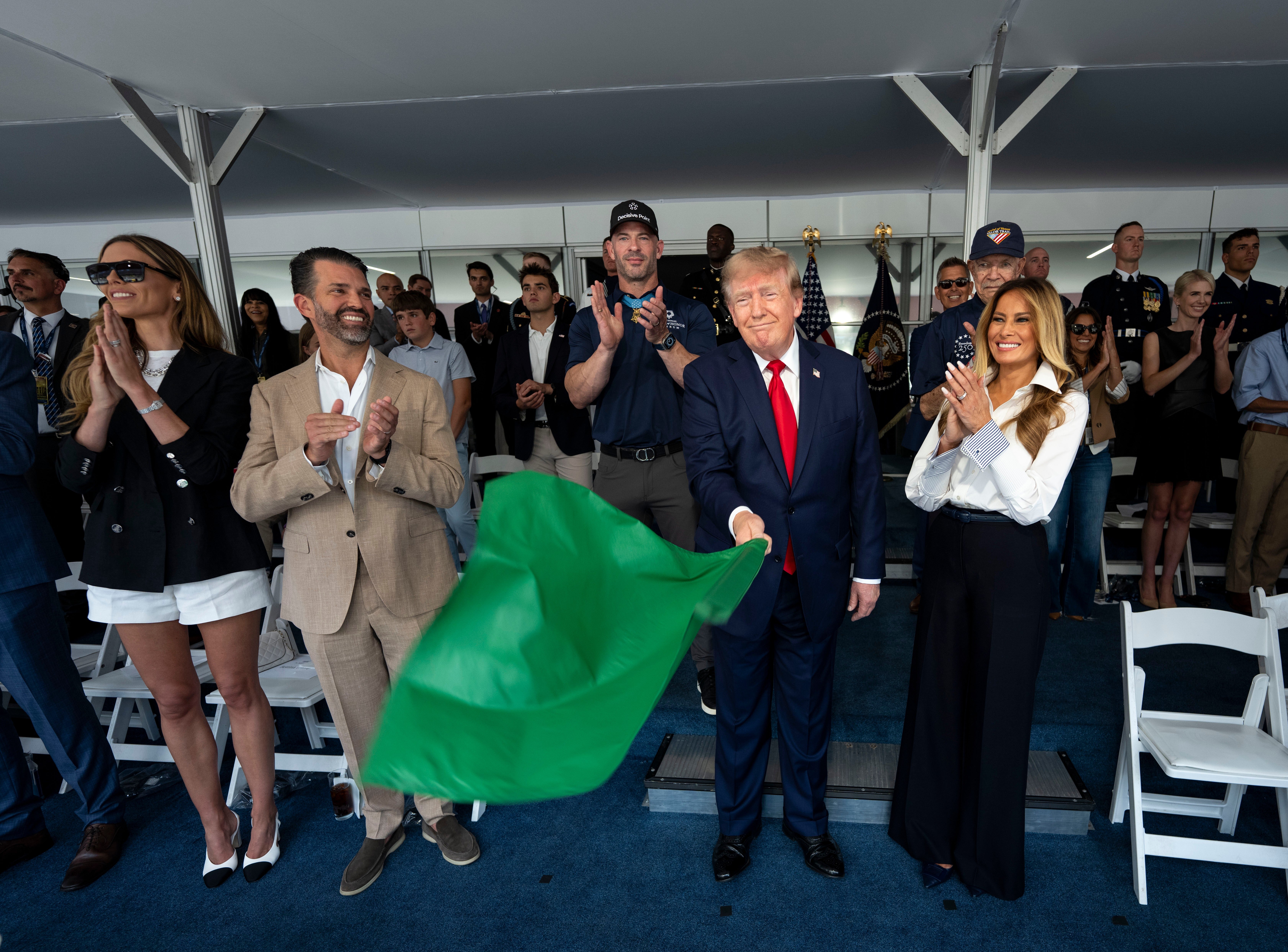 <p>President Trump’s family, members of his administration and close aides, such as Natalie Harp (pictured back right), surrounded him in the viewing stands for the Grand Prix</p>