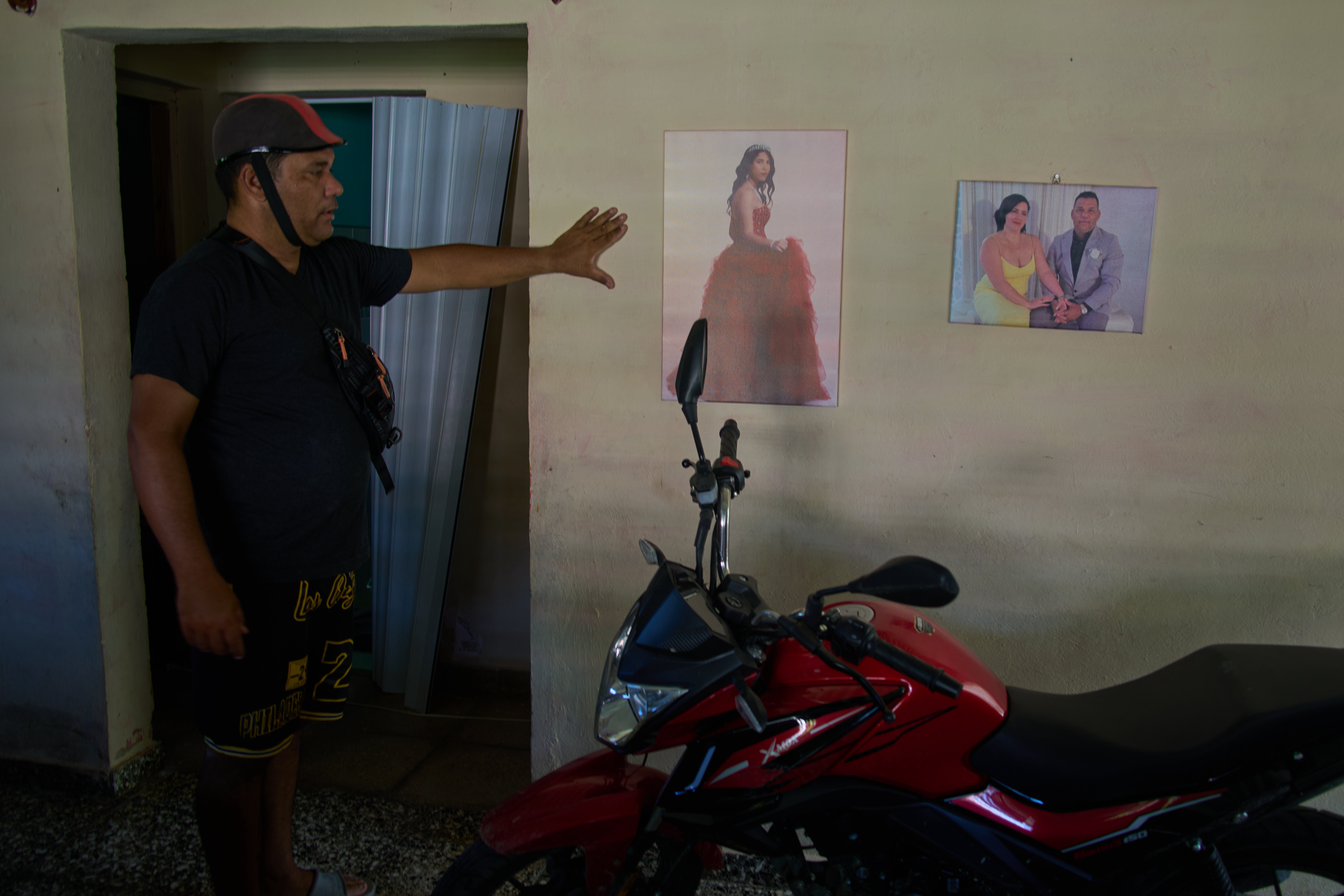 Liexer De La Cruz shows a photo of one of his daughters' 15th birthday and a photo with his wife taken at a friends' wedding in the United States