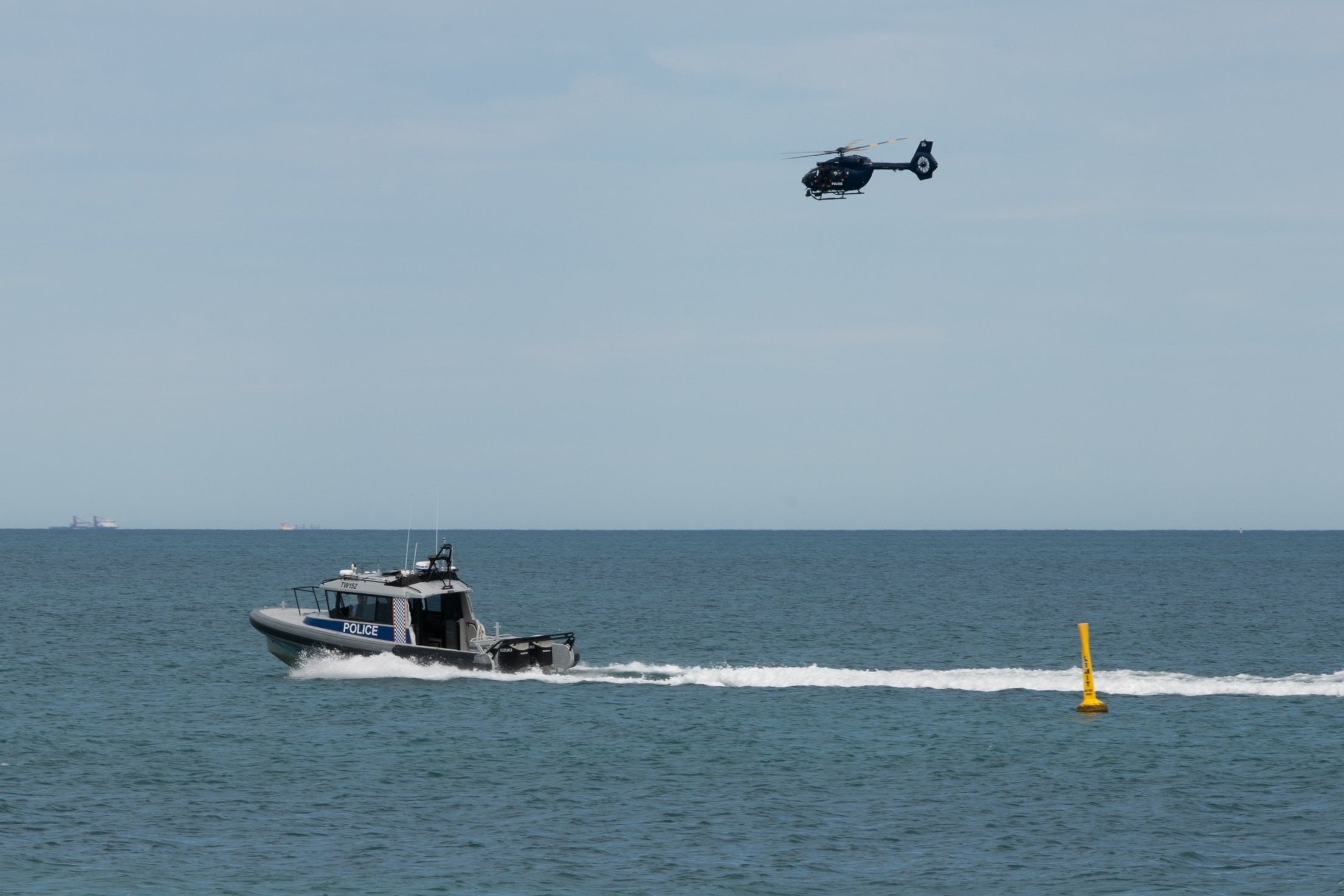 A police boat and helicopter patrol the area at Sorrento Beach