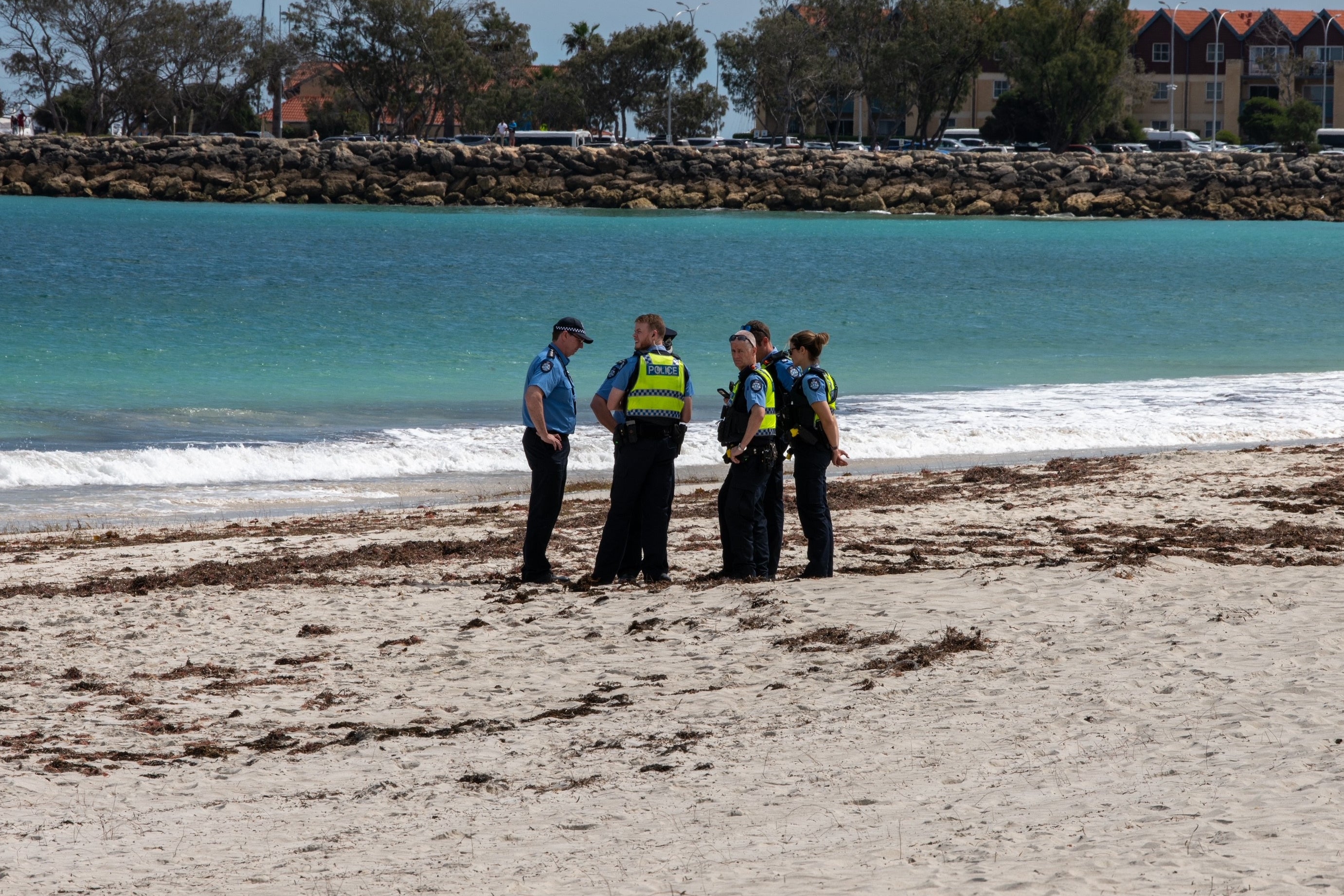 Police stand on Sorrento Beach, in Perth, Australia, Friday