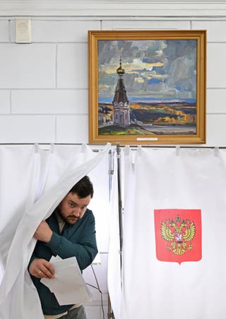 A man leaves a voting booth at a polling station on the first day of Russia's parliamentary election in Krasnoyarsk, Russia