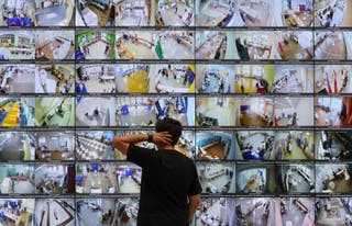 A man looks at screens showing live feeds from polling stations across the country at the headquarters of the Central Election Commission on the first day of Russia's parliamentary election in Moscow, Russia