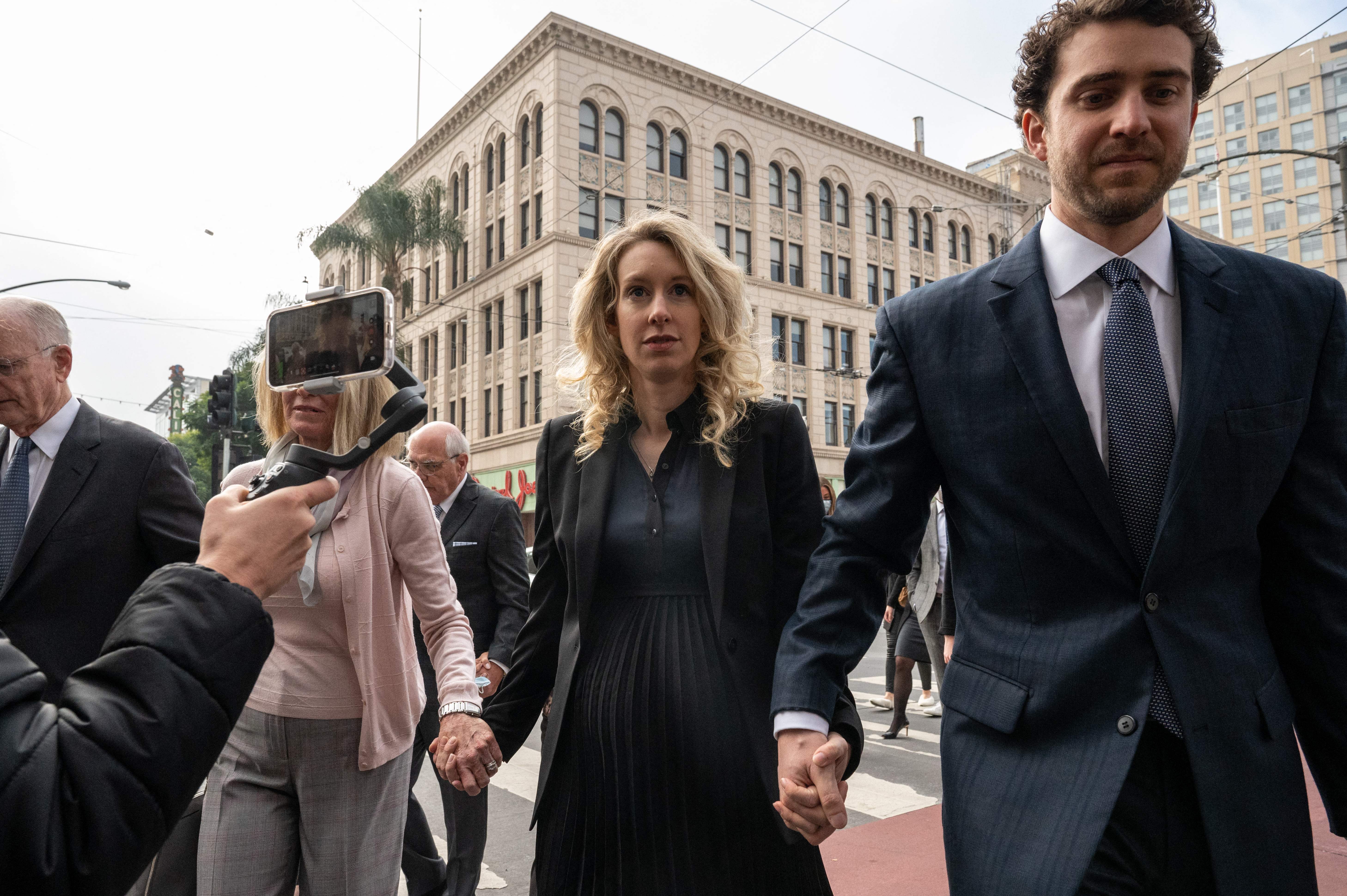 Holmes (center) and her partner William Evans (right), pictured in 2022, are at the center of the new documentary