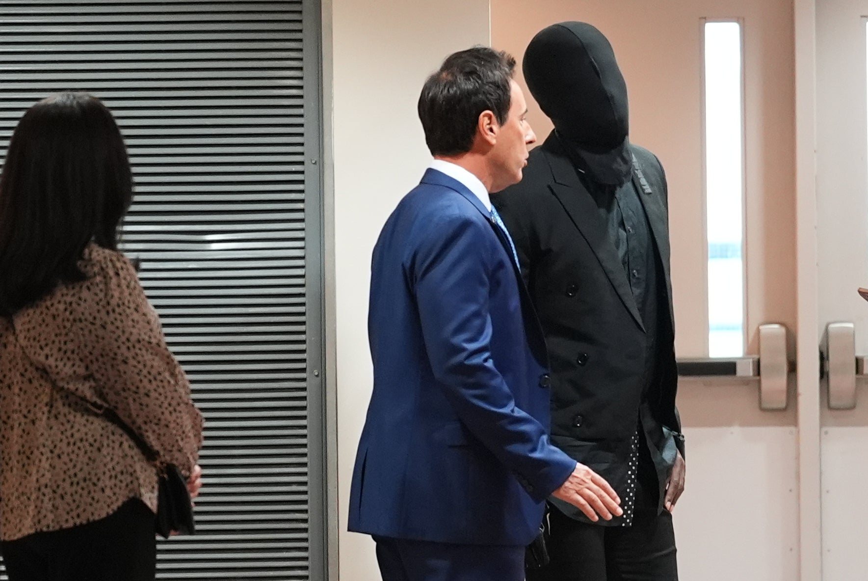 Former NFL player Antonio Brown wears a hood over his face as he speaks with his attorney Mark Eiglarsh before a court hearing Wednesday, Sept. 30, 2026, in Miami