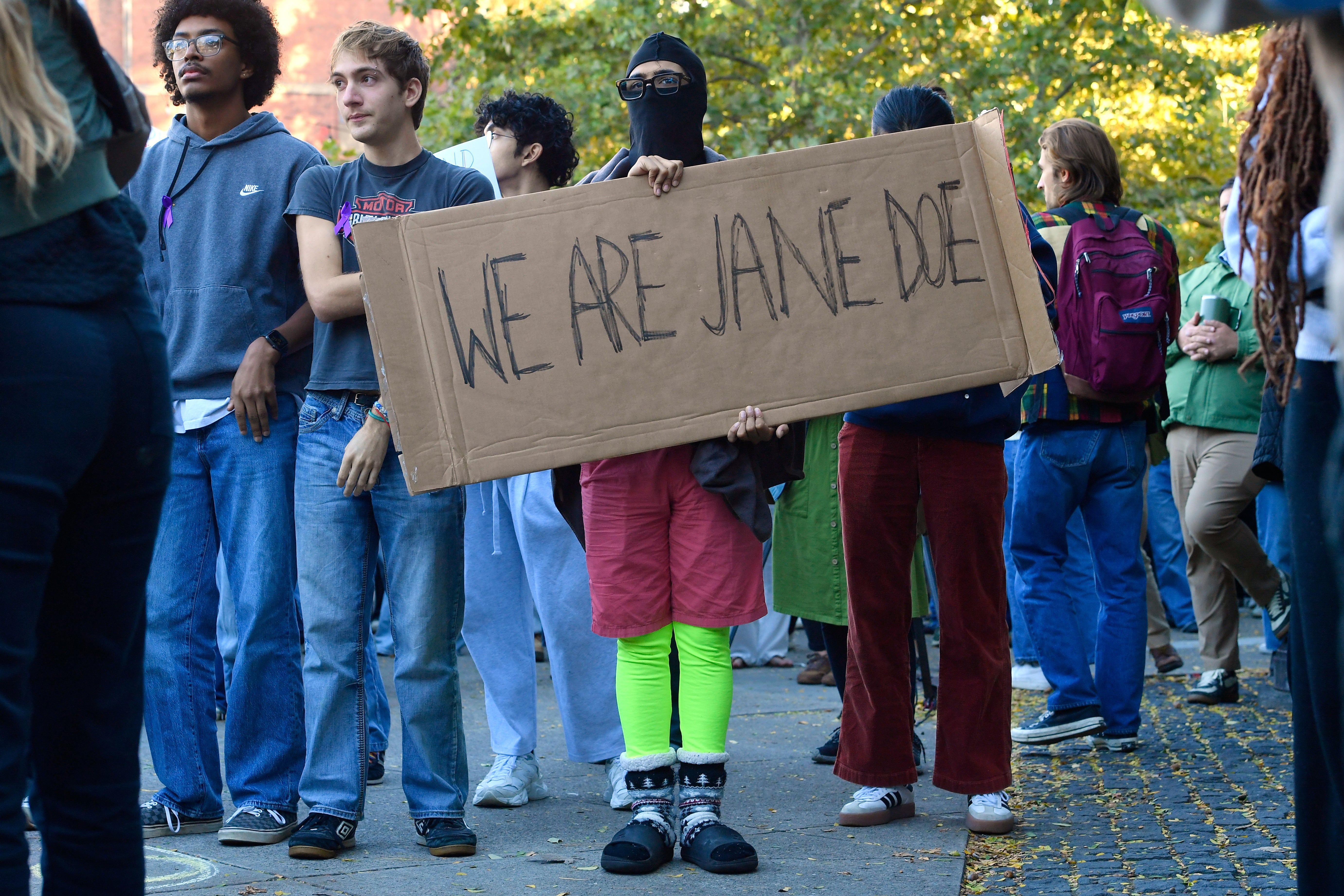 A demonstrator holds a sign reading "WE ARE JANE DOE" during a protest against Cornell University's handling of the alleged gang rape