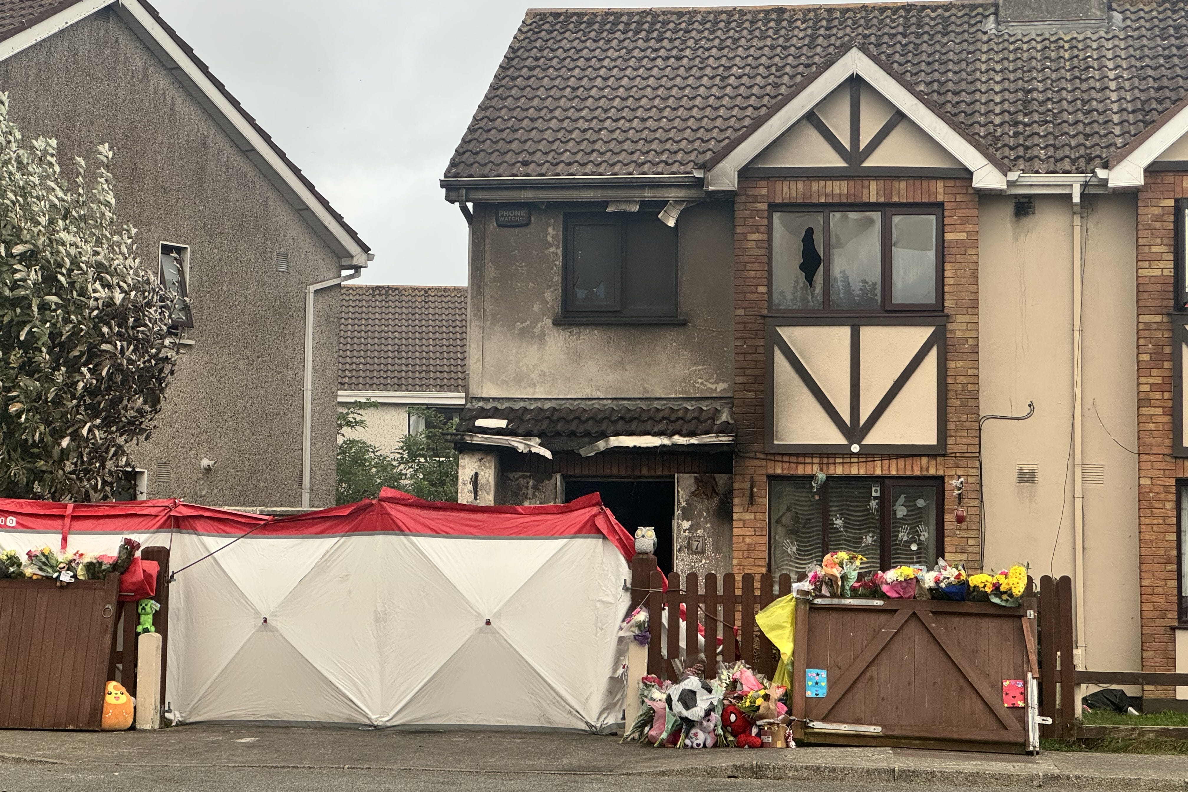 <p>Floral tributes outside the scene of suspected arson attack at a house in Birchwood, Waterford, which claimed the lives of two adults and two children. </p>