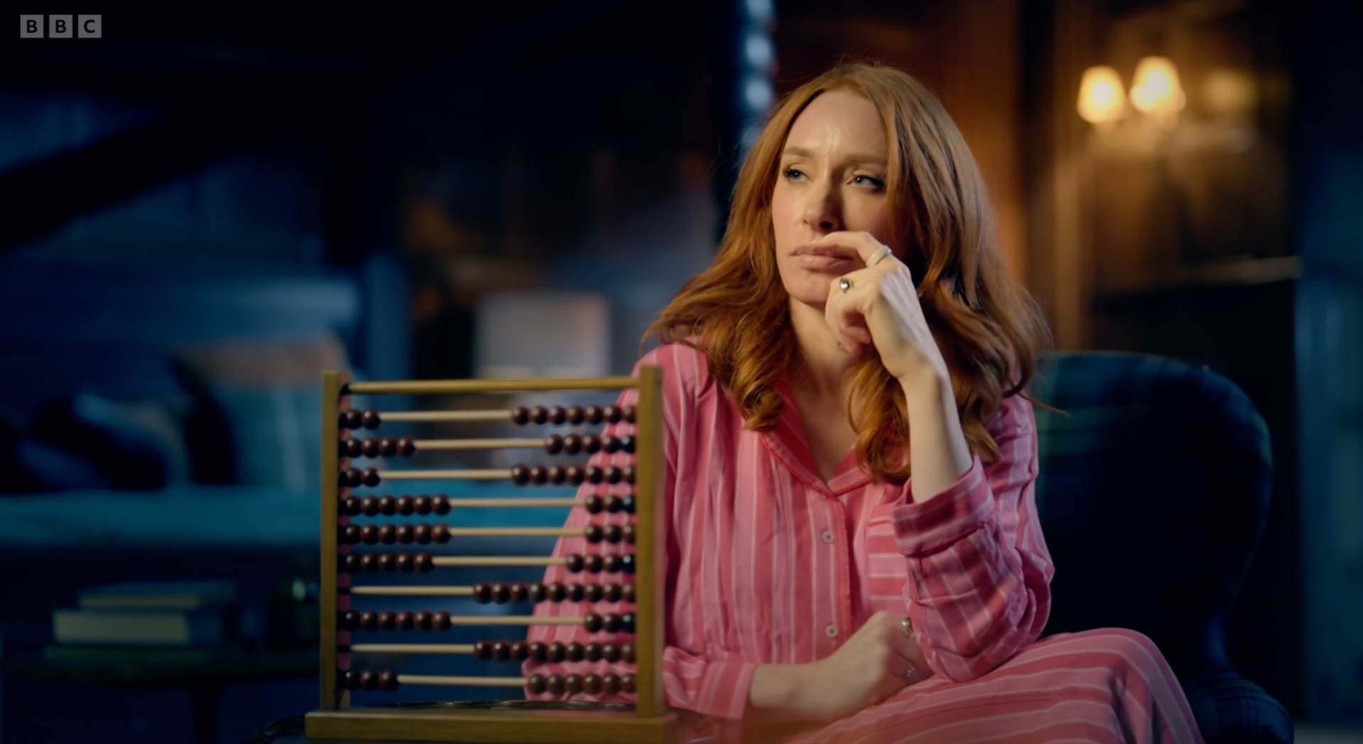 Professor Hannah Fry ponders while doing some calculations on an abacus