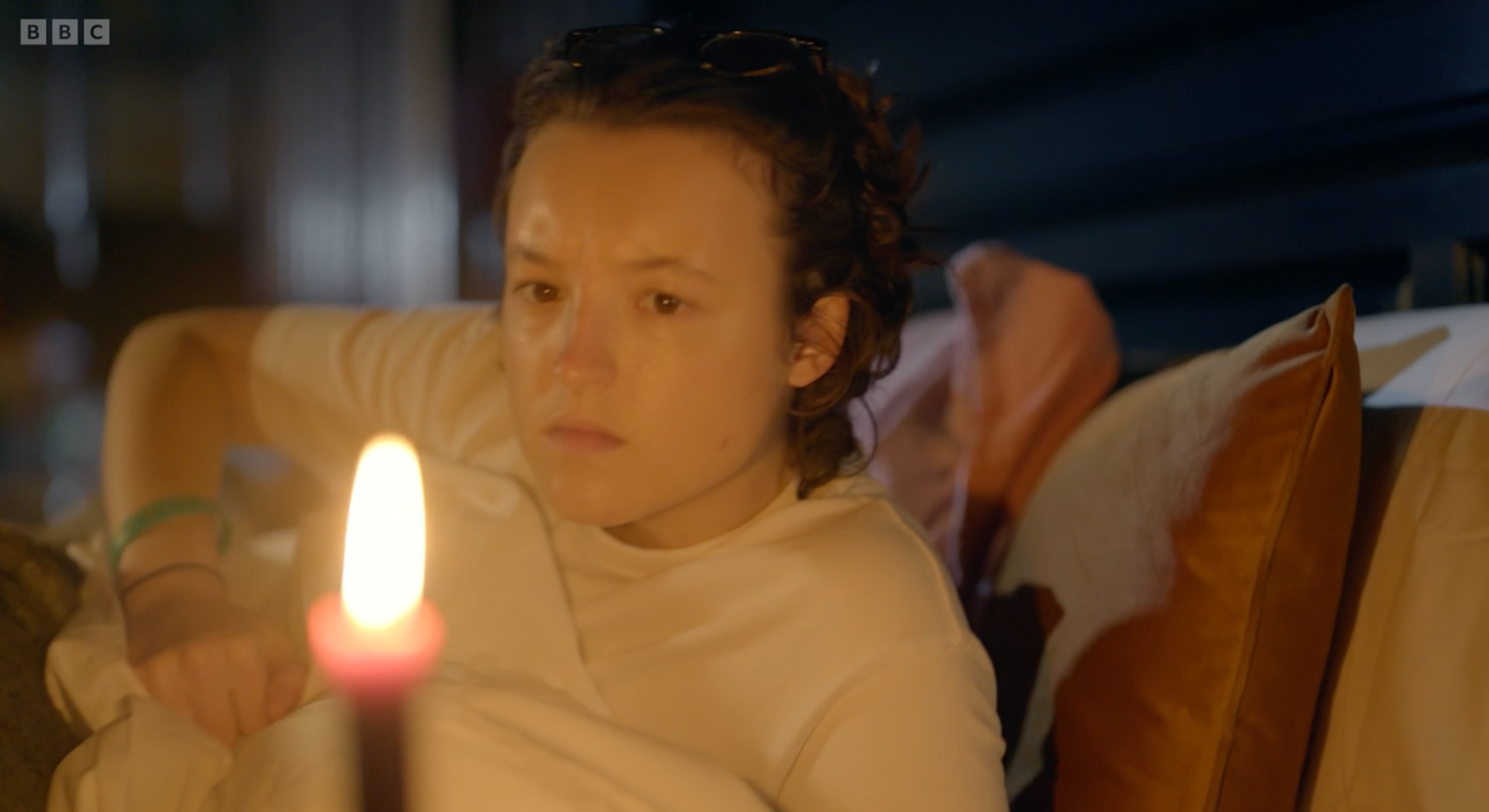 Bella Ramsey extinguishes their bedtime candle like a Victorian