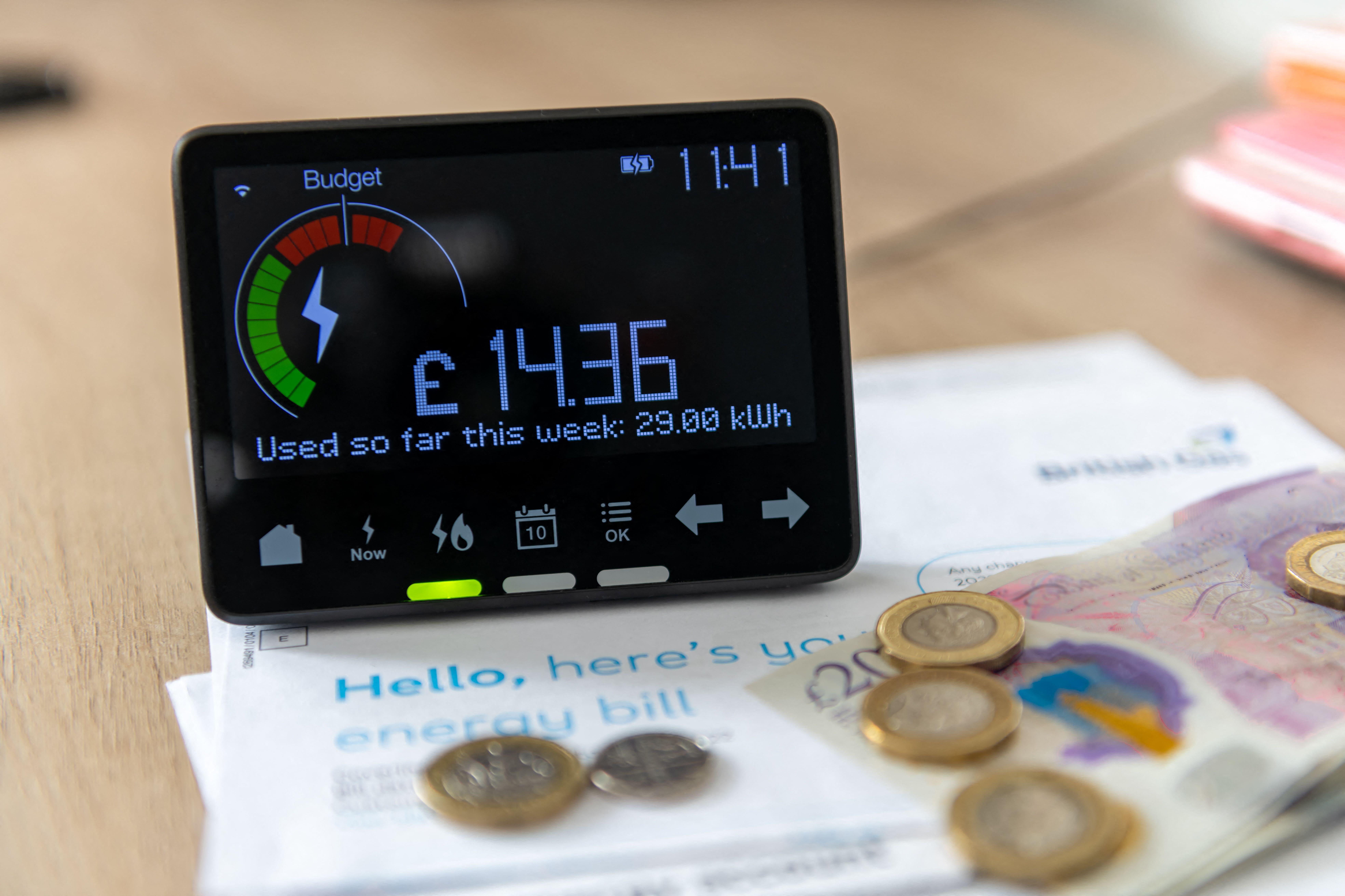 A smart energy meter showing latest reading surrounded by household energy bills and coins (Alamy/PA)