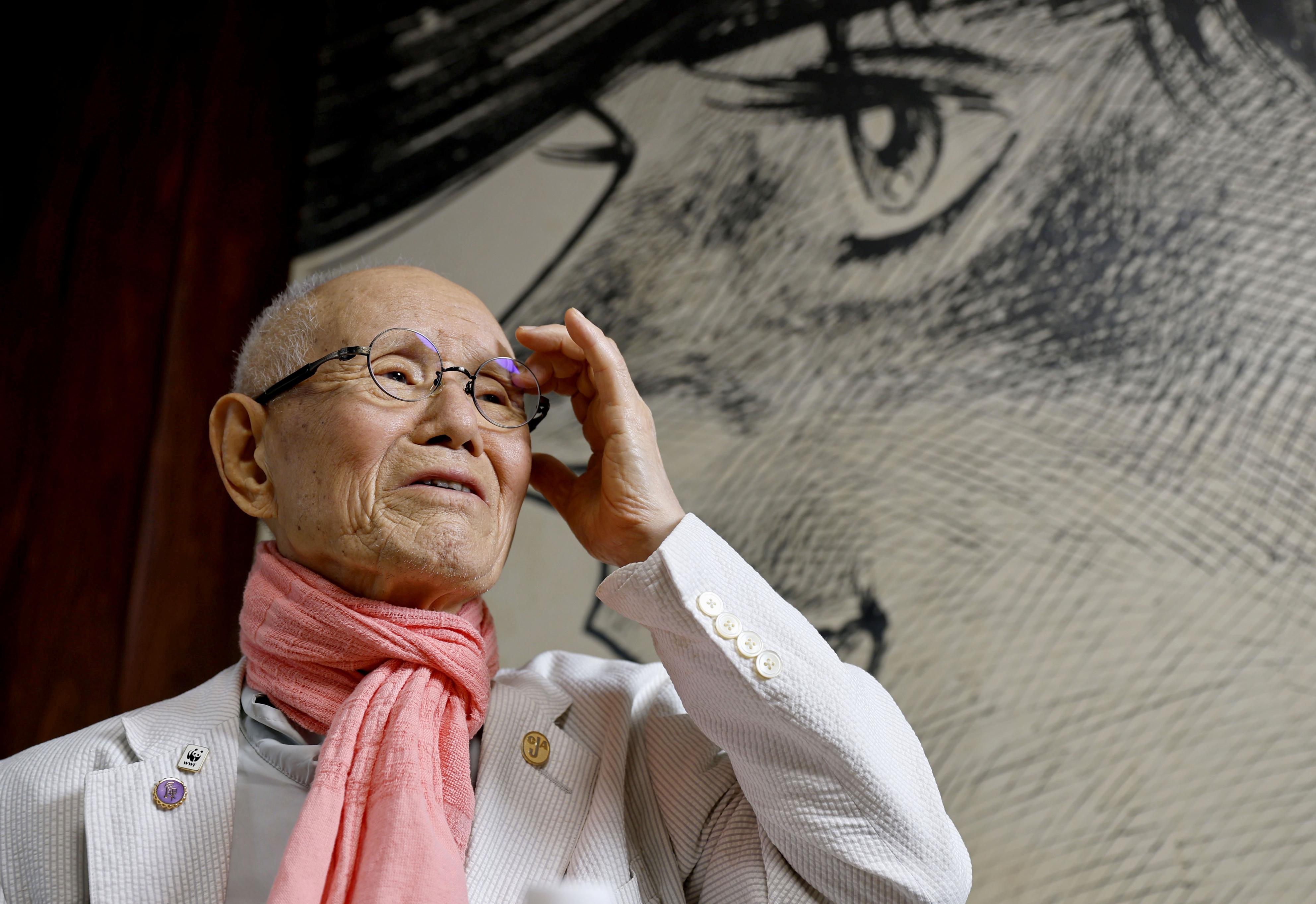 Japanese manga artist Tetsuya Chiba, poses for a photo in front of his boxing manga character in "Ashita no Joe," in Tokyo on June 18, 2026