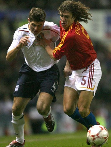 Steven Gerrard tussles with Spain's Carles Puyol