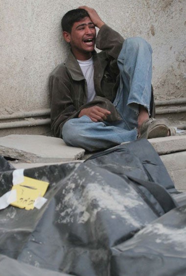 A relative grieves near body bags outside a Karbala hospital