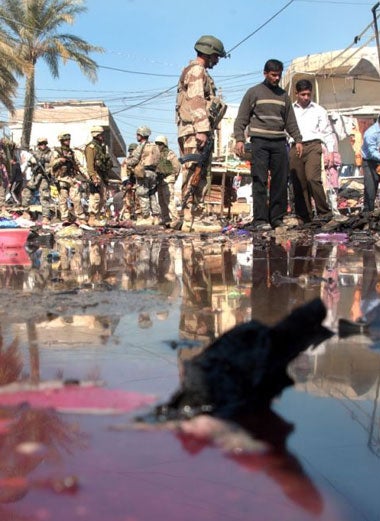 Iraqi soldiers inspect the scene after an explosion in Baqouba