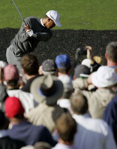 Woods is the centre of attention as he tees off during practice