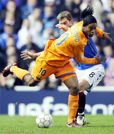 Rangers' Kevin Thomson tangles with Ronaldinho during the 0-0 draw with Barcelona at Ibrox