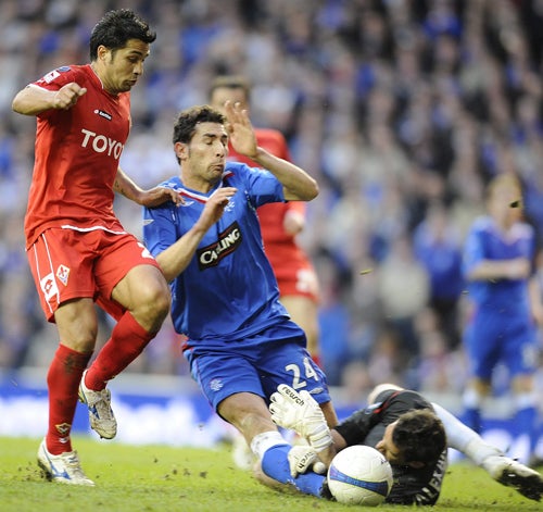 Fiorentina's Mario Alberto Santana (left) is just too late as the Rangers defender Carlos Cuellar and goalkeeper Neil Alexander snuff out an attack in the Uefa Cup semi-final first leg at Ibrox last night