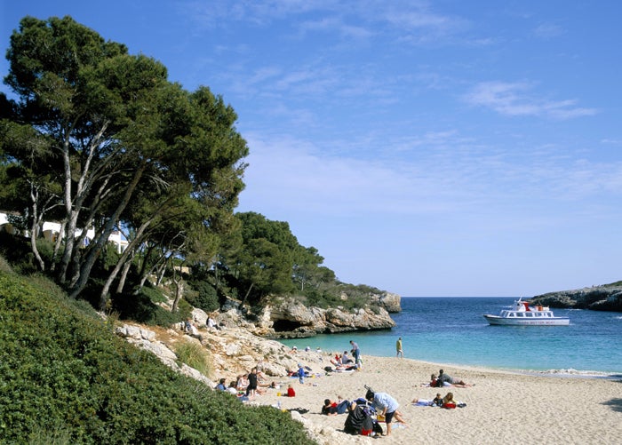 Tourists relax on the beach at Cala Esmeralda