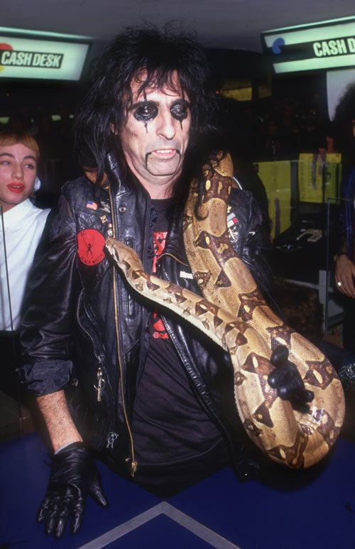 An adult boa constrictor, pictured with rocker Alice Cooper