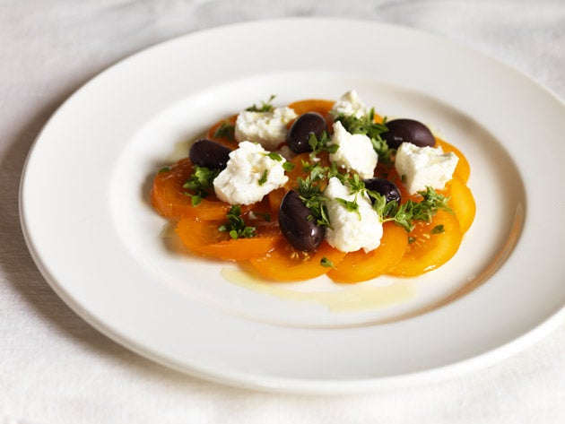 Arrange the sliced tomatoes, feta, black olives and basil on a serving dish and drizzle with olive oil