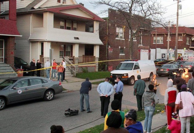 Neighbours watch as Cleveland police search the porch at the home of Anthony Sowell