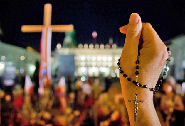 A woman holds a rosary during a rally