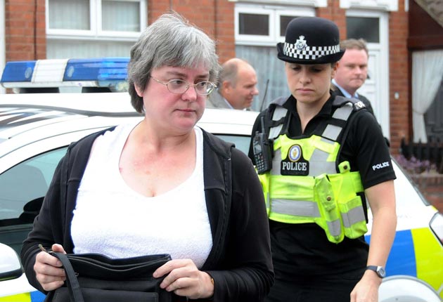 Ms Bale is escorted by police to her front door after an online campaign led to national press outrage and death threats