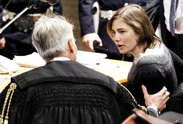 Knox speaks to her lawyer Carlo Della Vedova in the courtroom before a trial session