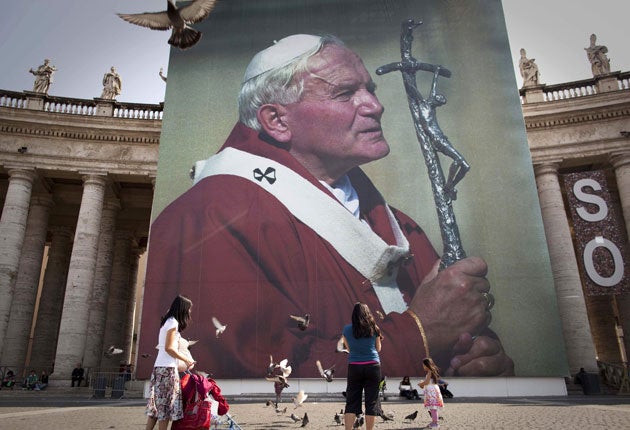 A photo of the late Pope John Paul II hanging from a stage set up near St Peter's Square in Rome