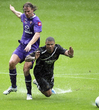 Splashing time: Leon Best takes a plunge at St James' Park under a challenge from Fiorentina's Cesare Natali before the referee Mark Halsey decided to call a halt