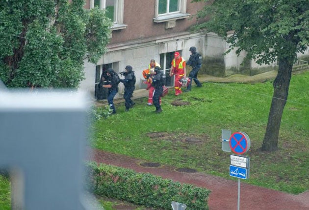 Estonian police escort emergency medics into the cordoned-off Defence Ministry building in Tallin