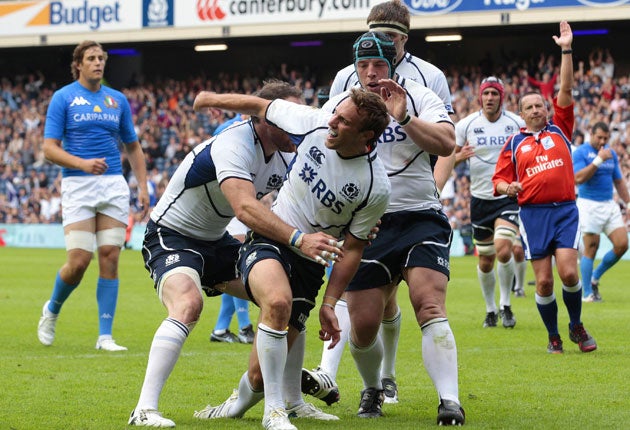 Mike Blair is congratulated by his team-mates after scoring Scotland's first try against Italy at Murrayfield on Saturday