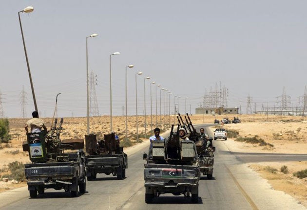 Rebel fighters patrol the road near the village of Heisha