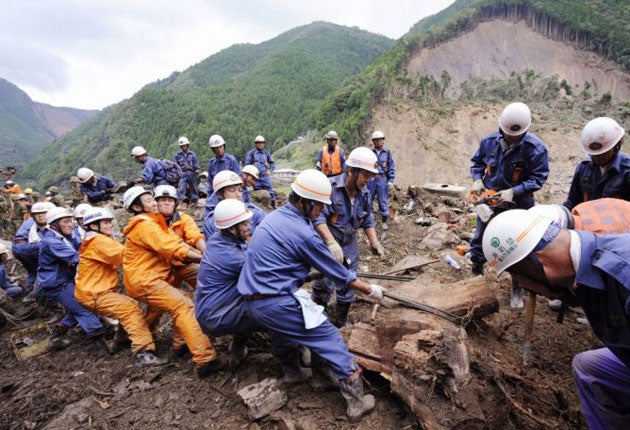 Rescue workers search for missing people among the debris in Gojo