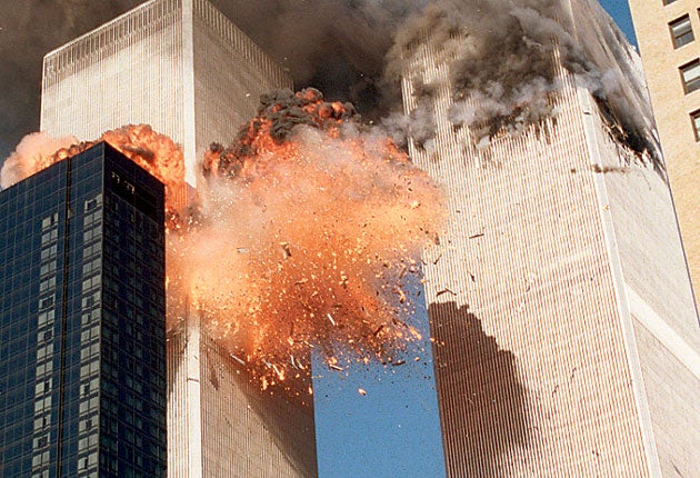 Smoke billows from one of the towers of the World Trade Center and flames and debris explode from the second tower