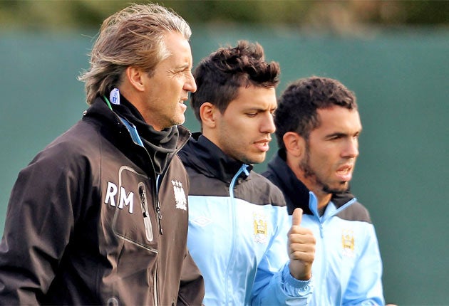 Manchester City manager Roberto Mancini with Sergio Aguero and Carlos Tevez during a training session at Carrington