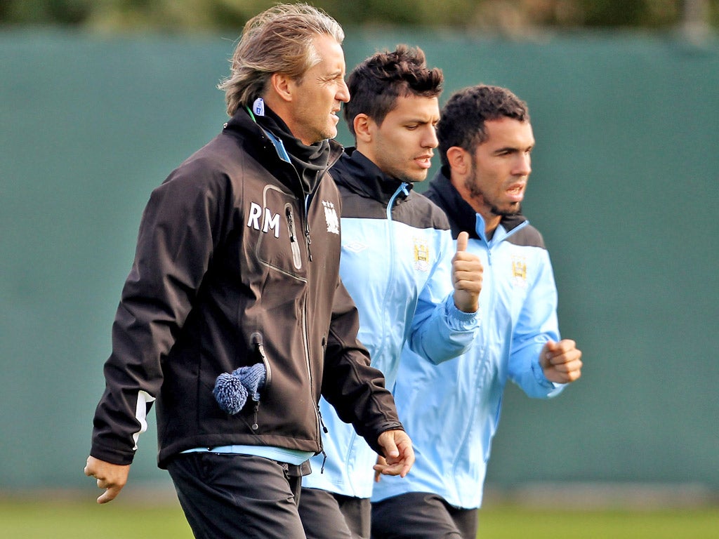 Roberto Mancini (left) has given Carlos Tevez (right) hope he could play for City again