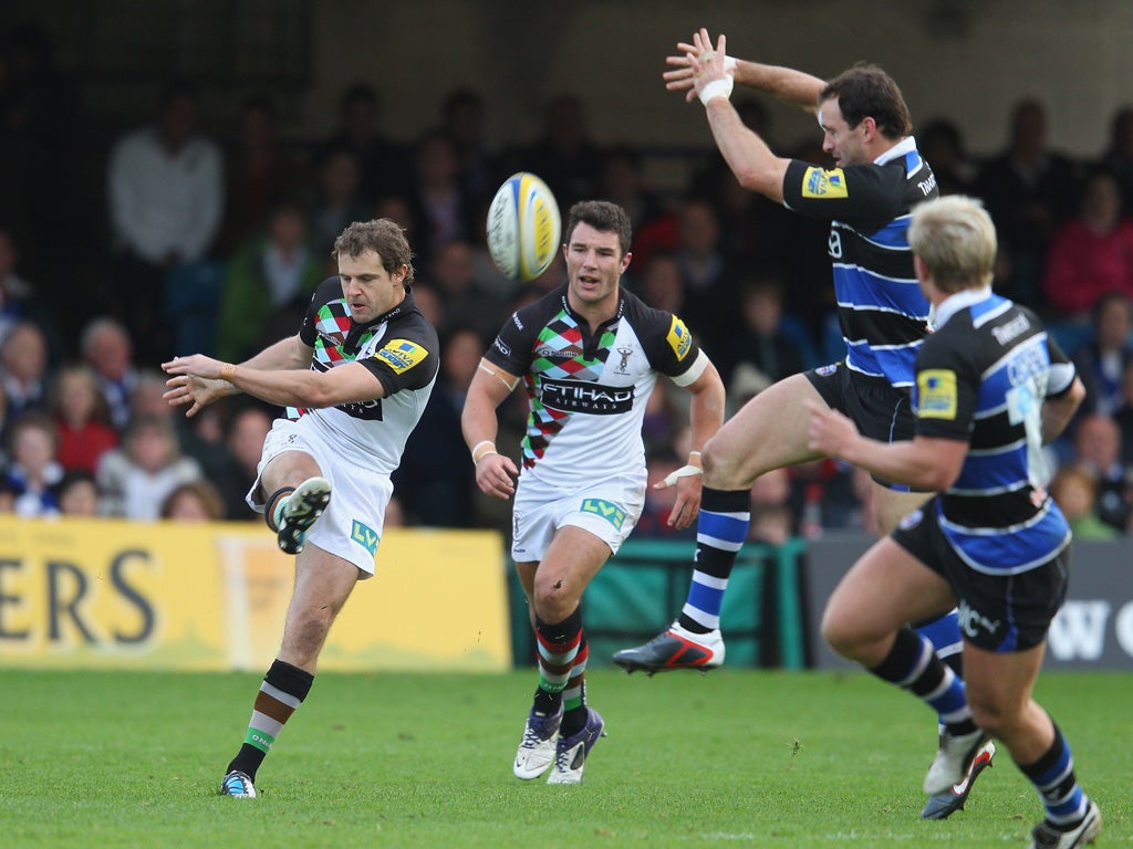 Evans above: Nick Evans, Harlequins' former New Zealand fly-half, kicks over the Bath defence during his team's victory at the Recreation Ground