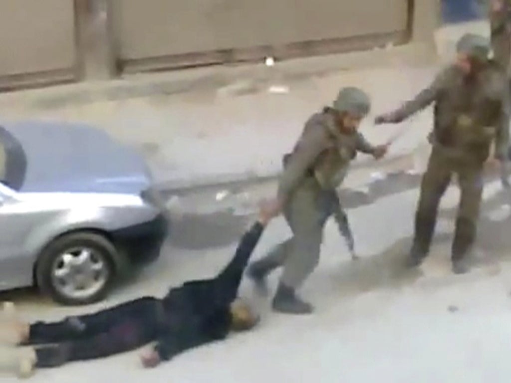 A body is dragged away by security forces in Damascus