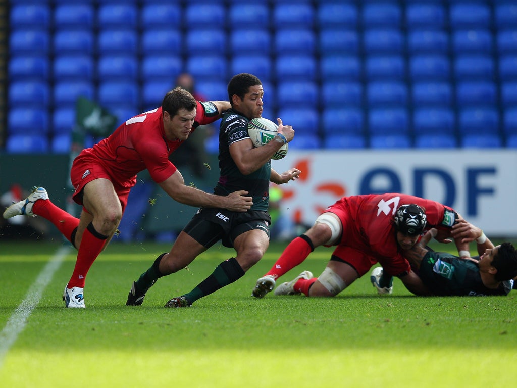 Joe Ansbro, London Irish's Scotland back, is tackled by the Edinburgh wing Tim Visser