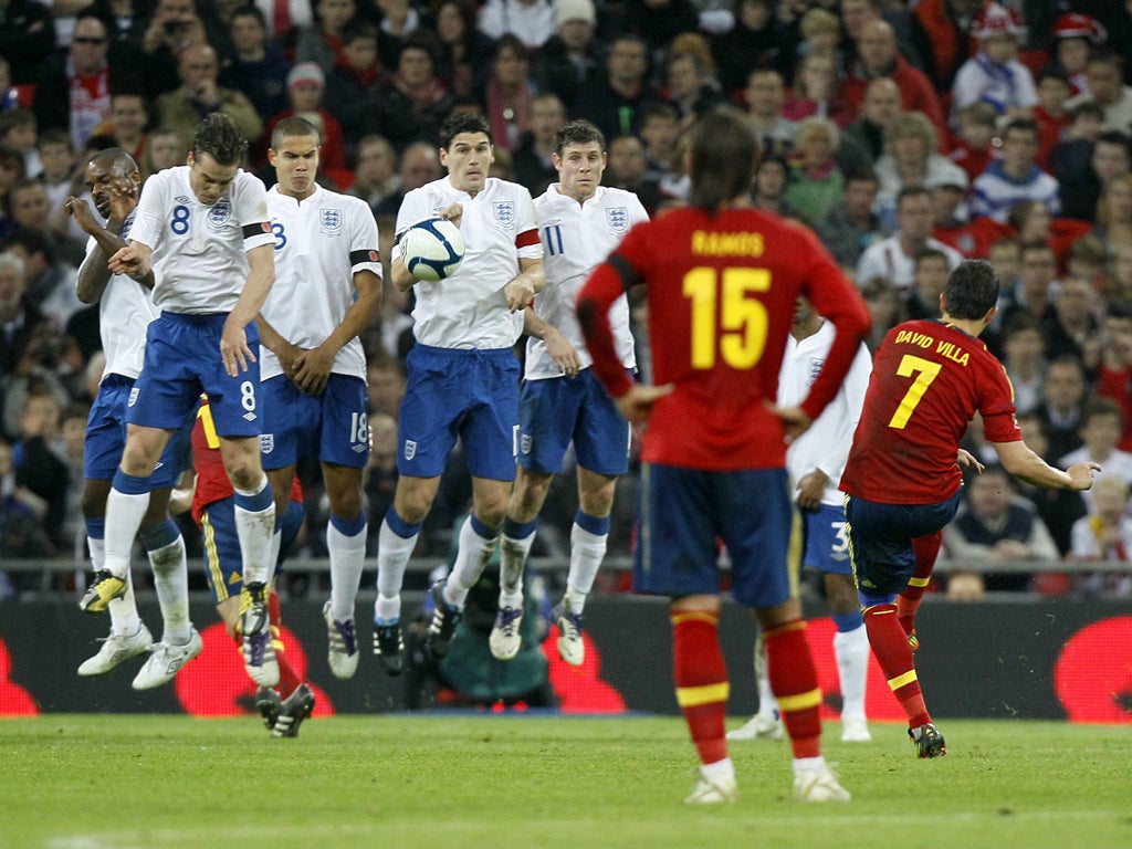 England's wall jumps as one to prevent David Villa's free-kick from causing trouble