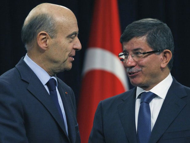 French Foreign Minister Alain Juppe, left, and his Turkish counterpart Ahmet Davutoglu shake hands after the news conference in Ankara