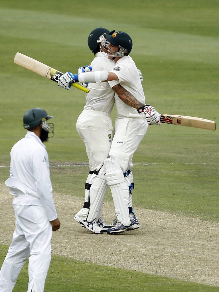 Hashim Amla looks on as Pat Cummins (right) celebrates with Mitchell Johnson