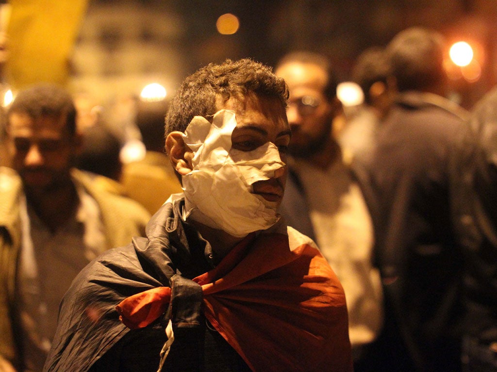 An injured Egyptian protester walks in Tahrir square in Cairo