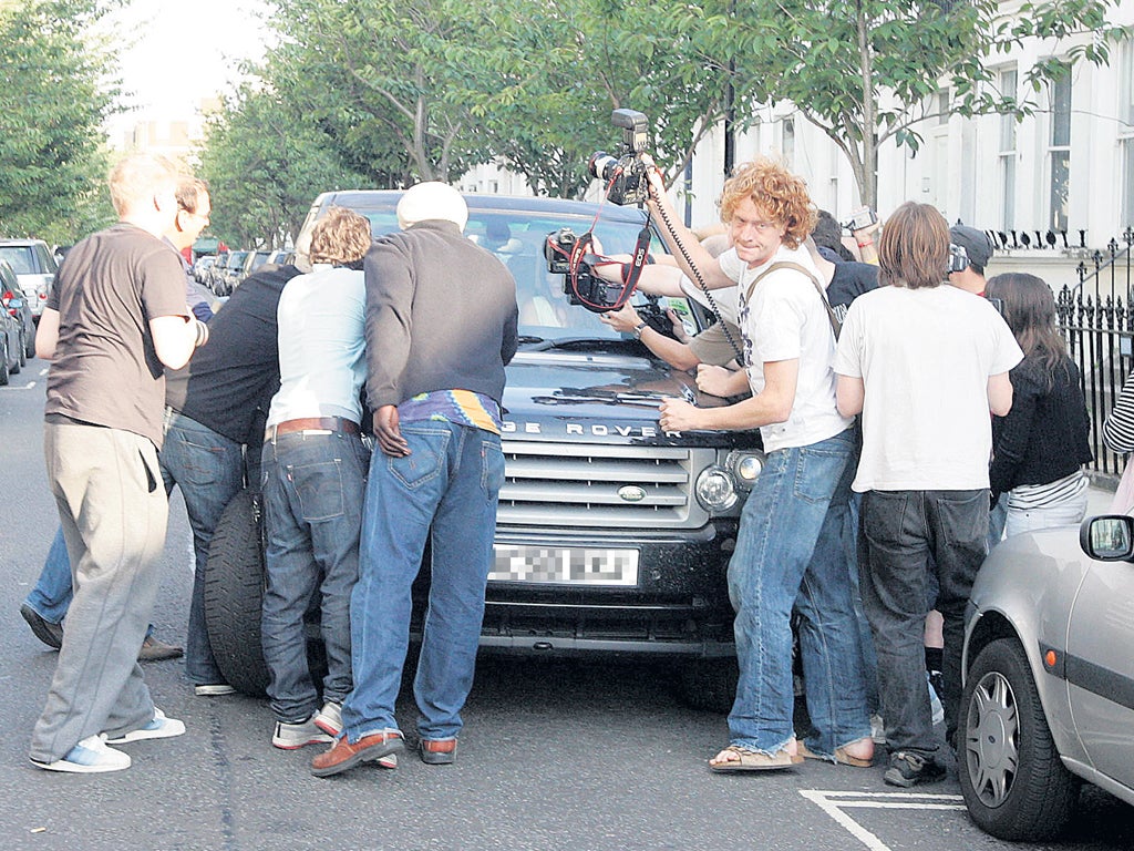 Liz Hurley surrounded by paparazzi outside her home