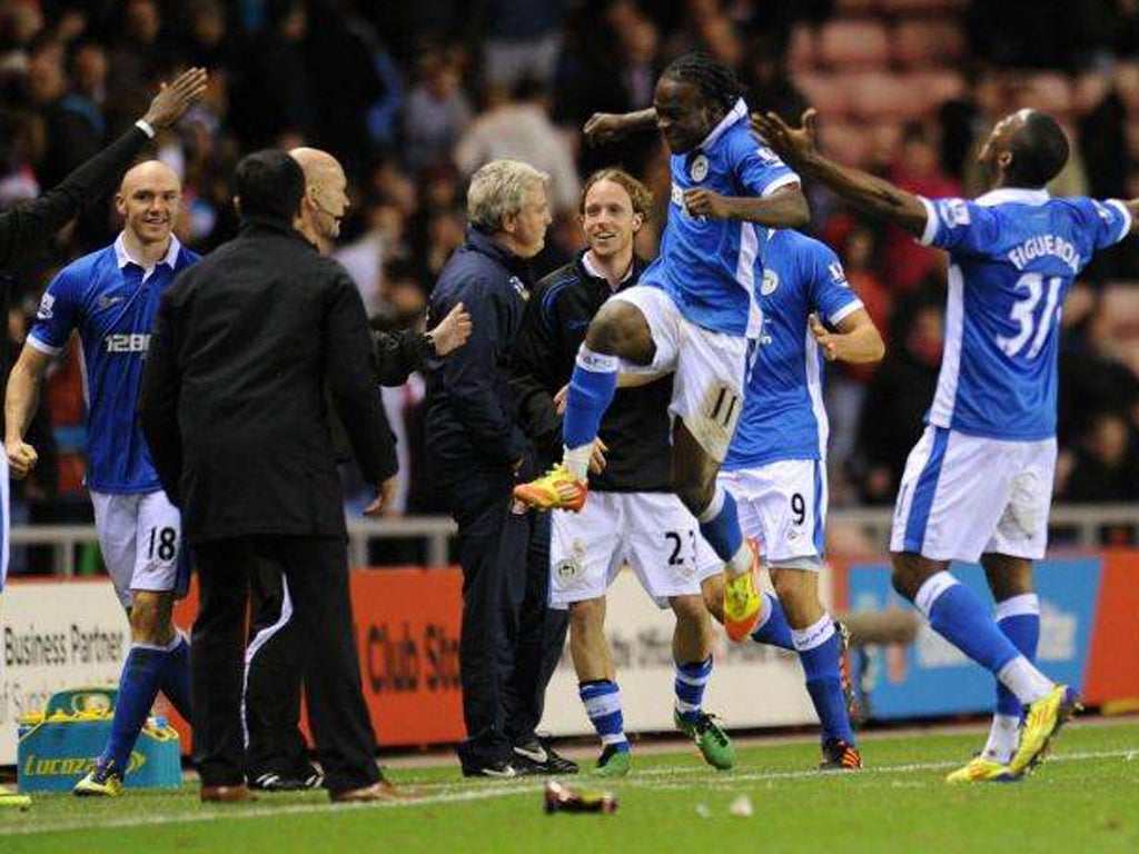 Steve Bruce (centre) endures the pain of defeat as Wigan celebrate