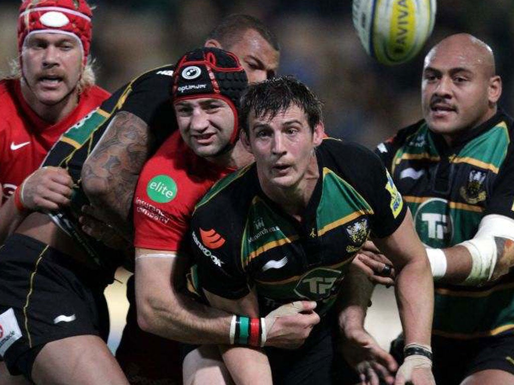 Northampton flanker Tom Wood (centre) is hauled back by former England captain Steve Borthwick