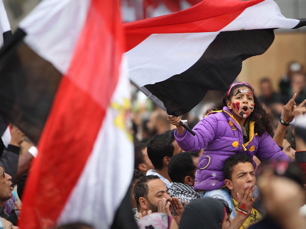 A girl waves a flag as she and other protesters remain in Tahrir Square yesterday