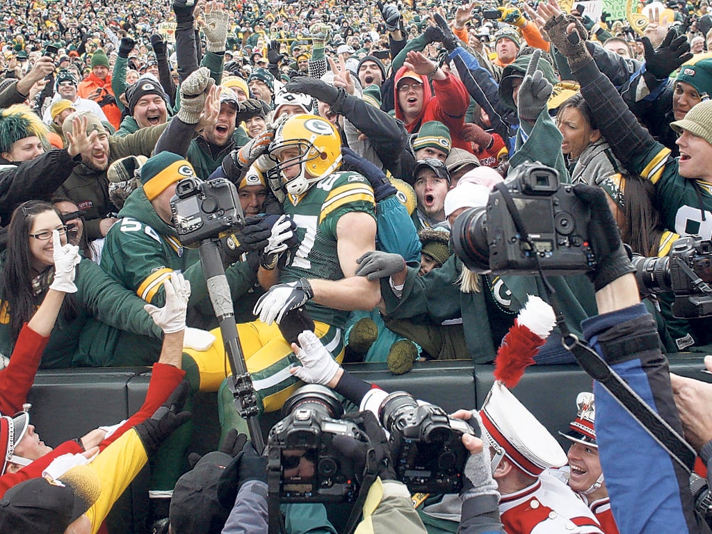 Jordy Nelson is engulfed after doing the traditional
'Lambeau Leap' following a touchdown