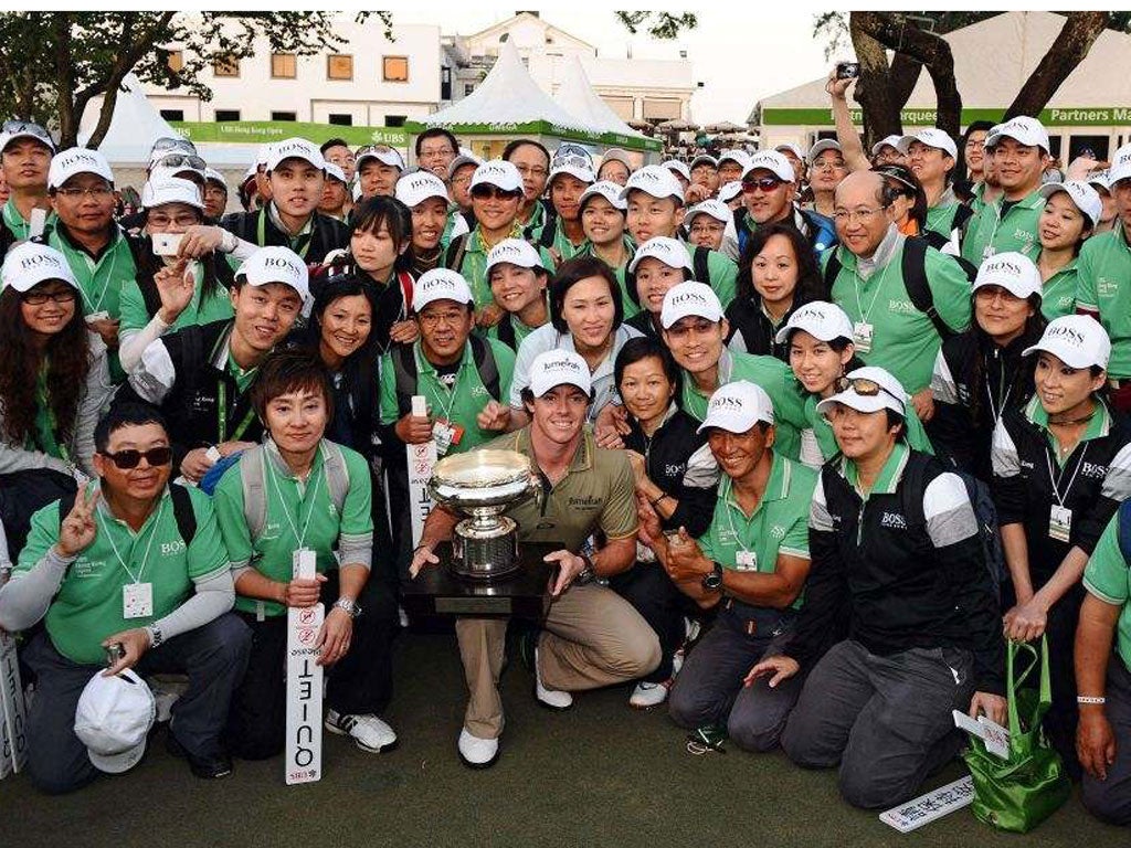 Rory McIlroy poses with the trophy and tournament
volunteers after winning the Hong Kong Open