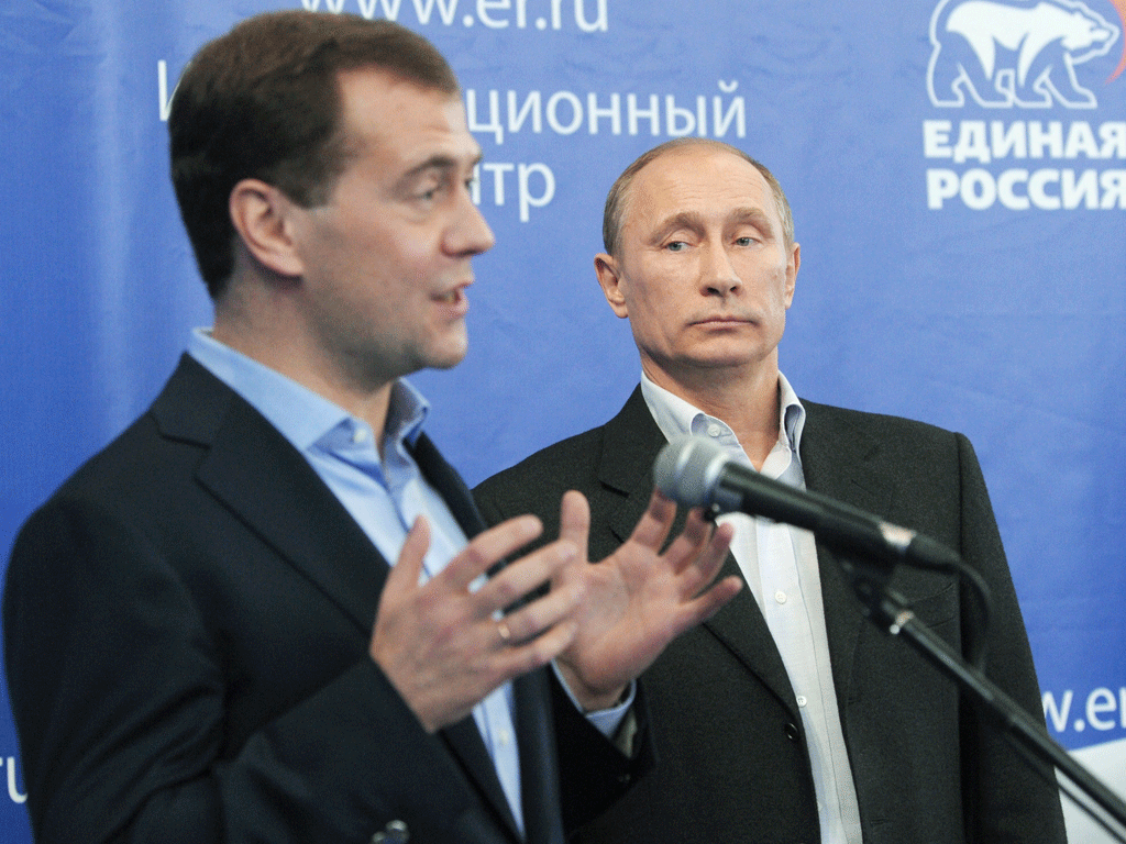 Russia's President Dmitry Medvedev (left) and Prime Minister Vladimir Putin speak to their supporters in the United Russia ruling party's campaign staff in Moscow